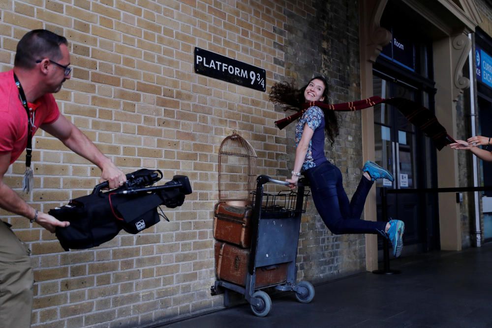 Una mujer posa en la estación 9 y 3/4 de la estación londinense de la Estación de Kings Cross, en fechas del 20 aniversario de la publicación del primer libro de la saga Harry Potter.