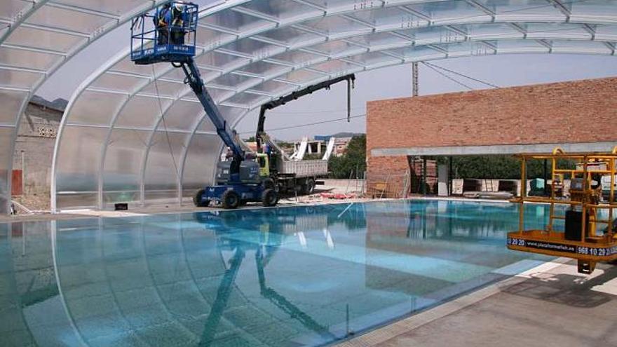 Imagen de los trabajos de instalación de la cubierta móvil en la piscina.