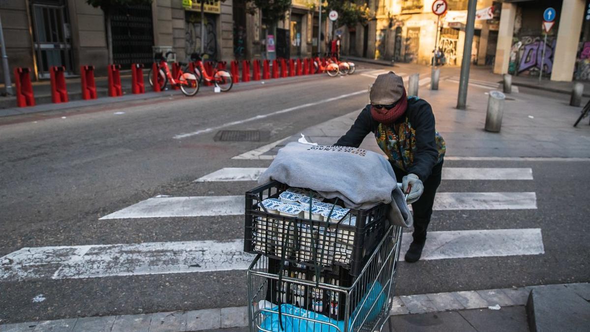 Un miembro del Sindicato Popular de Vendedores Ambulantes reparte comida a los manteros más vulnerables