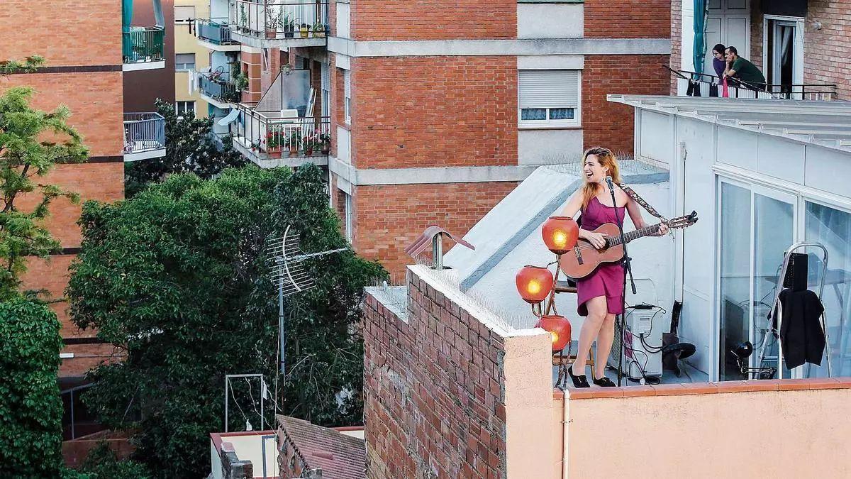 La cantante Tori Sparks canta a sus vecinos en el terrado de su casa del barrio de Horta de Barcelona en el confinamiento de la primavera de 2020. /