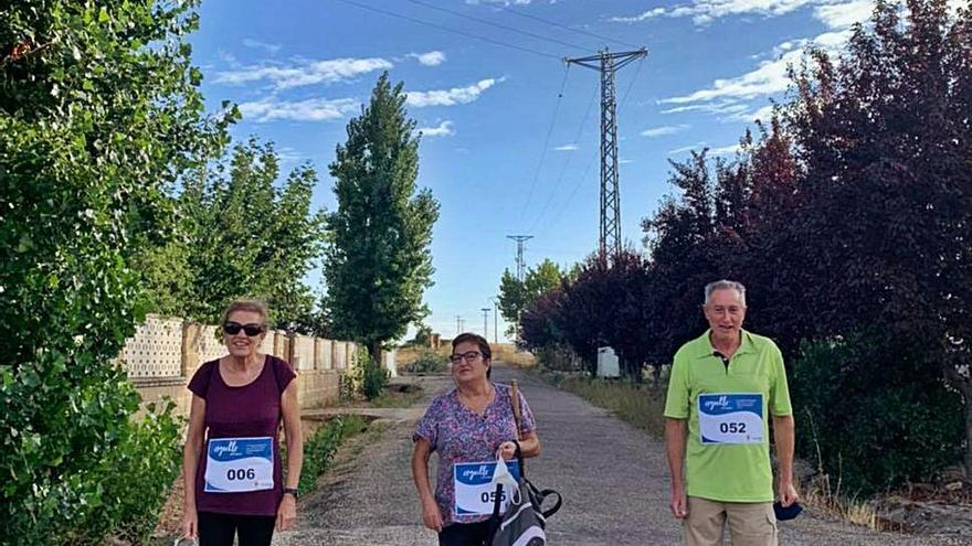 Tres vecinos durante la marcha solidaria. | Cedida