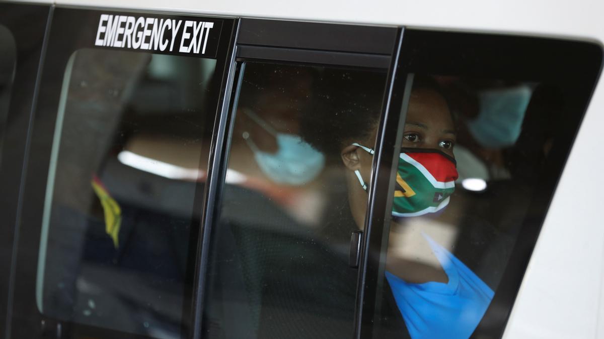 A passenger in a taxi wears a face mask with colours of the South African flag after the announcement of a British ban on flights from South Africa because of the detection of a new coronavirus disease (COVID-19) variant, in Soweto, South Africa, November 26, 2021. REUTERS/Siphiwe Sibeko