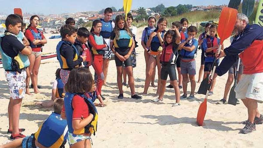 Los participantes en el campus de piragüismo atienden las instrucciones de su monitor en Panxón.