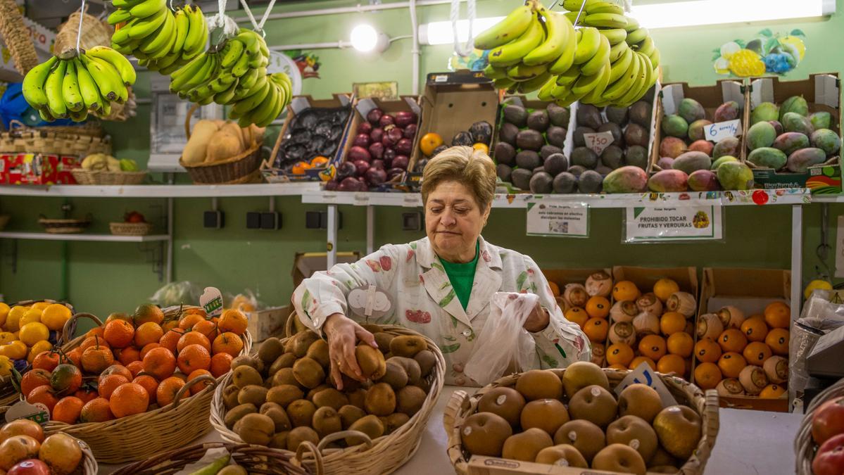 Una mujer atiende en una frutería.