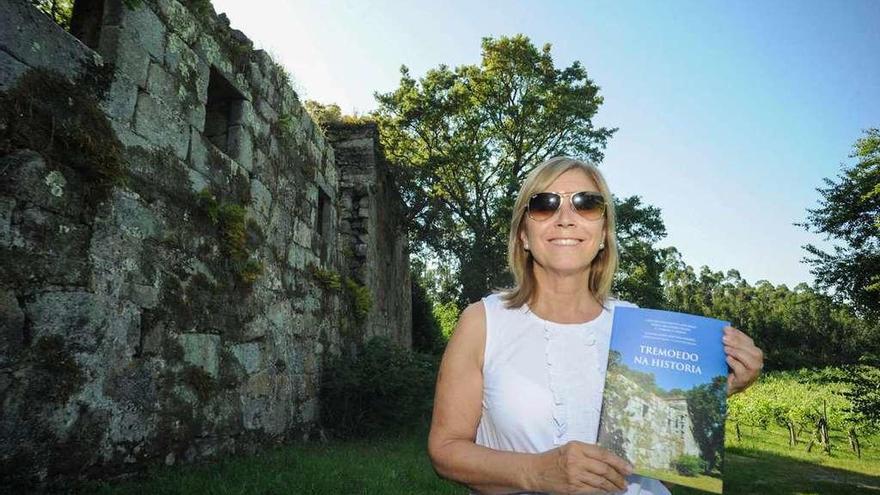 Carmen Villanueva posa con el libro &quot;Tremoedo na Historia&quot; ante la torre de Xafardán. // Iñaki Abella