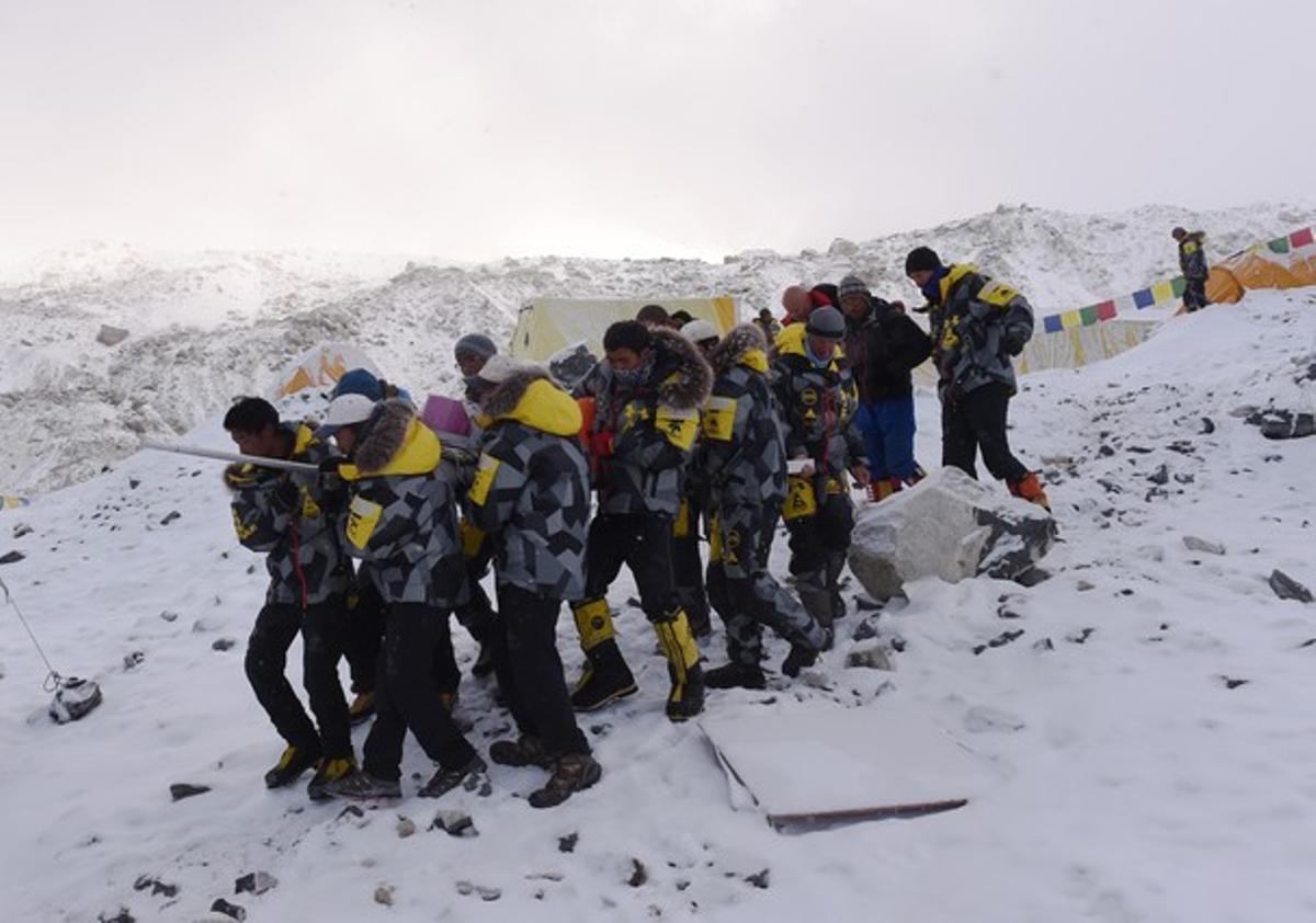 Varios compañeros transportan a un compañero herido en el campo base del Everest