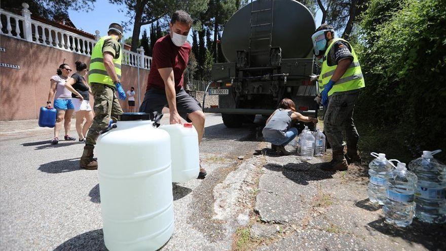 Vecinos de Las Jaras rellenan garrafas de agua tras un corte en el suministro en el verano del año pasado.