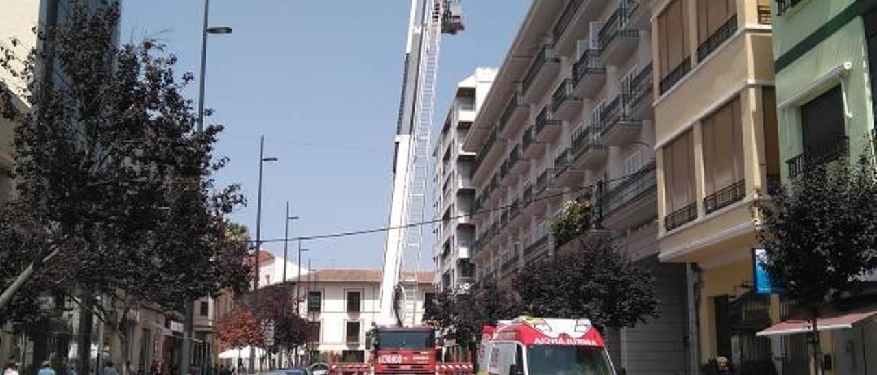 Momento en que el brazo articulado de los bomberos desciende al herido de la azotea.