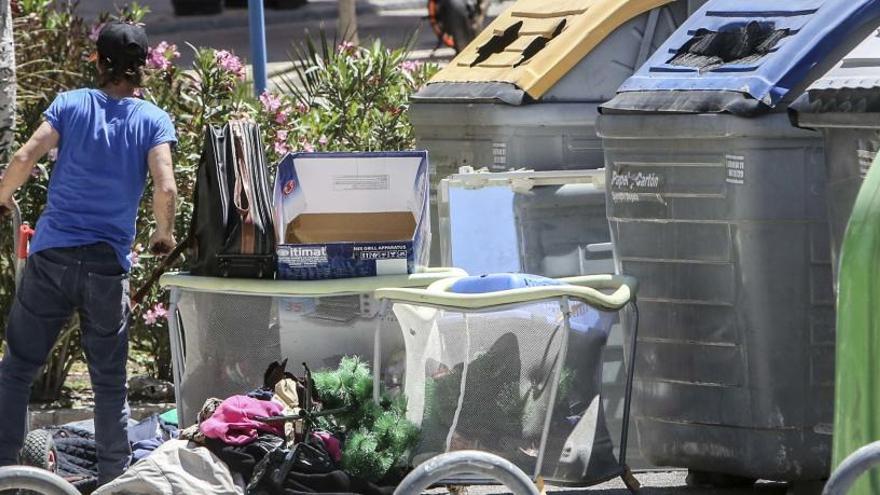 Un ciudadano, junto a basura, en una calle de Alicante.