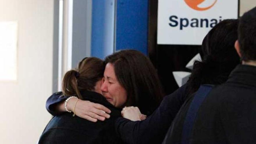 Dos empleadas de Spanair en el aeropuerto de Ibiza se abrazan tras la quiebra de la compañia.