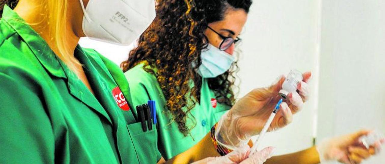 Dos médicas internas residentes preparando vacunas para administrar.  | | JOSÉ CARLOS GUERRA