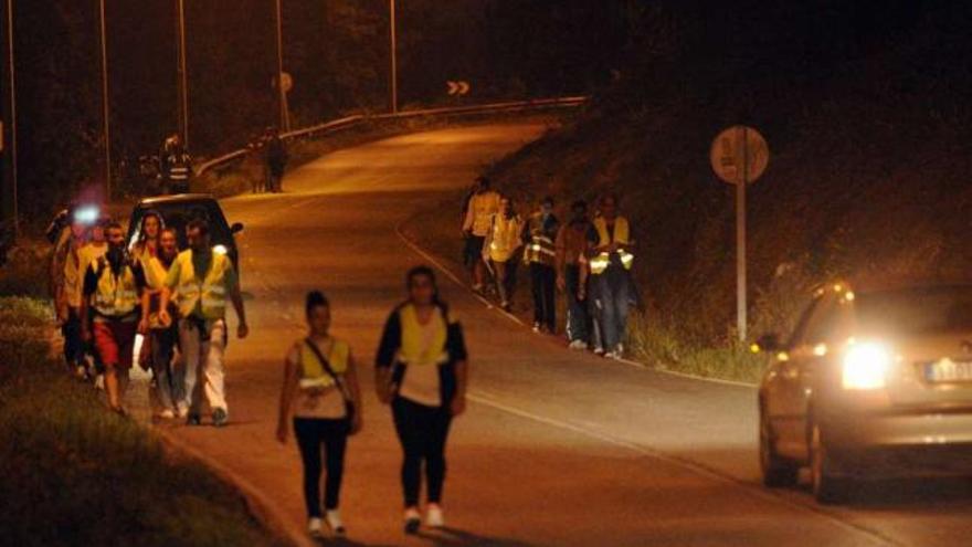 Un grupo de personas camina de madrugada con chaleco reflectante.  // Noé Parga