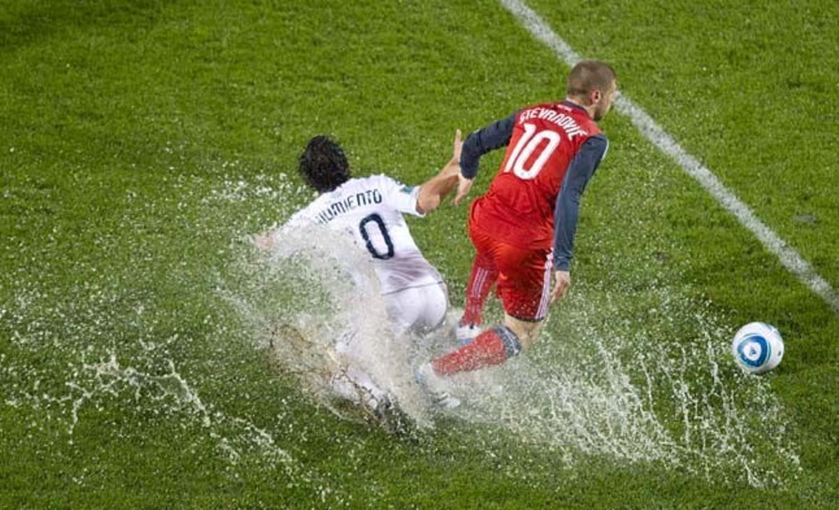 Alen Stevanovic, de Toronto FC, s’emporta la pilota davant l’entrada del jugador dels Vancouver Whitecaps, Davide Chiumiento, durant la final del campionat canadenc de futbol que va haver de ser suspesa per la forta pluja.