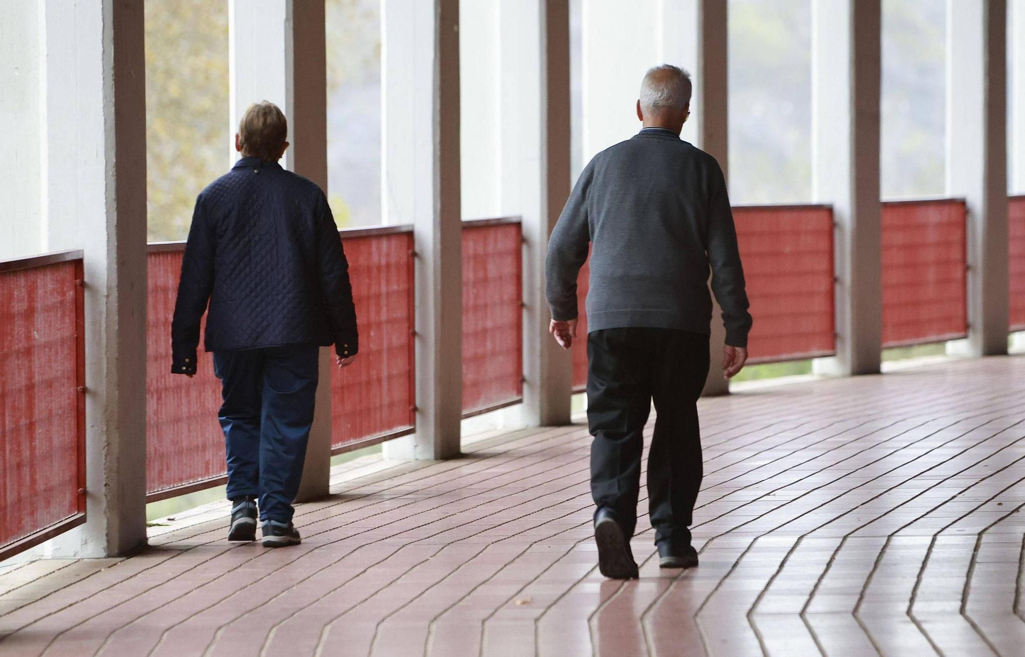 Dos personas mayores dando una caminata por las inmediaciones del estadio municipal de fútbol Vero Boquete de Santiago.