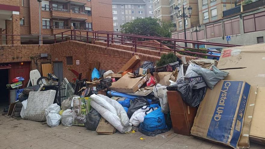 Los vecinos del garaje de Oviedo donde la tromba de agua dañó 50 coches y anegó los trasteros denuncian que la basura aún sigue acumulada en la zona