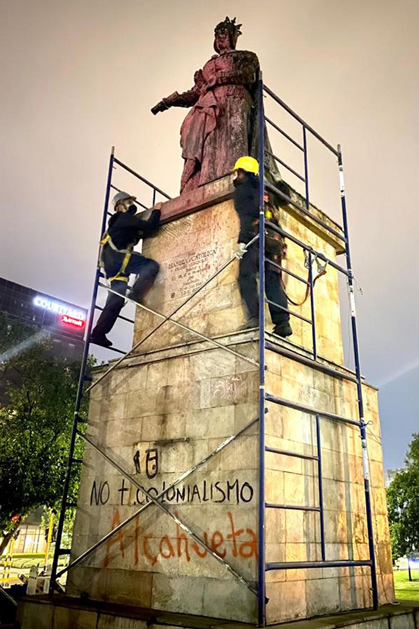 Unos operarios se disponen a trasladar la estatua de Isabel I en Bogotá.