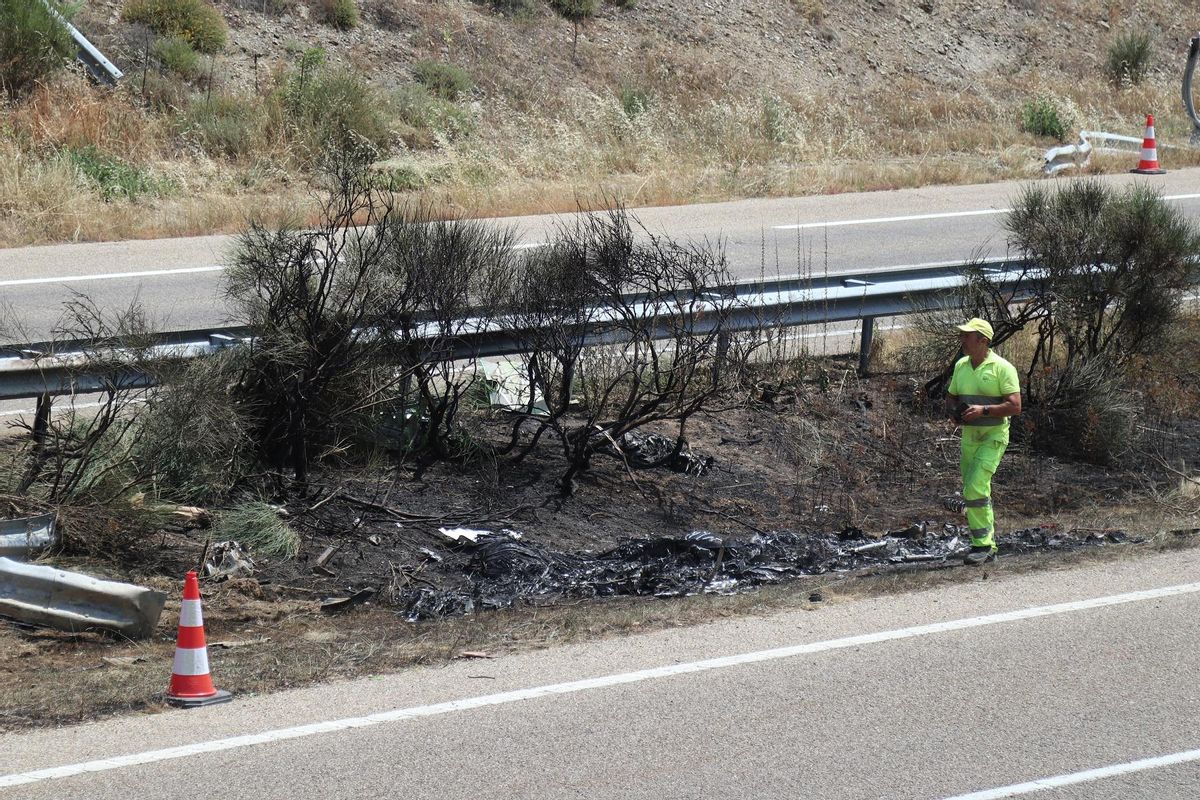 Un operario de carreteras, en el lugar en el que quedó calcinado en la mediana el vehículo.