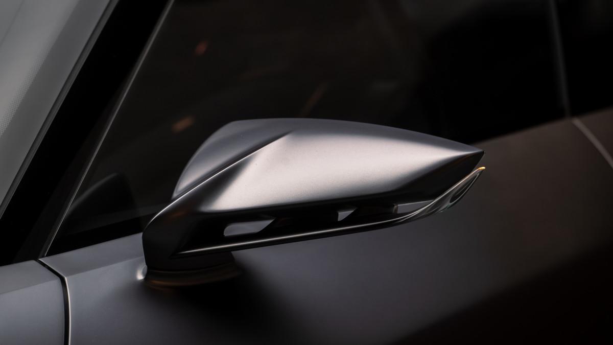 El espejo retrovisor tiene una forma de cola de ballena, con aberturas funcionales y acabados satinados que refuerzan la aerodinámica.
