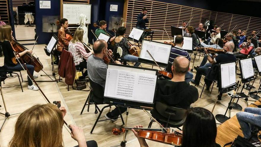 Arriba, Oviedo Filarmonía, durante uno de los ensayos. A la izquierda, una recreación del escenario de &quot;Casal Sinfónico, Trono Vacío&quot;.