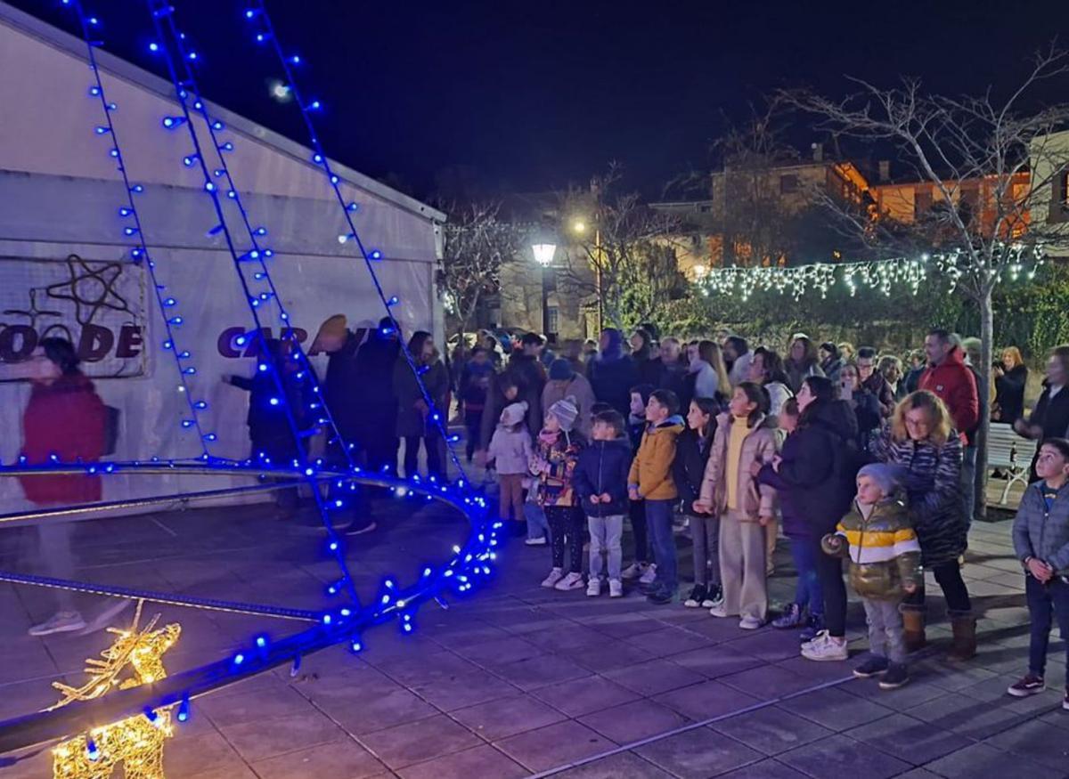 Niños contemplan la iluminación navideña de Caravia, Debajo, Vidaflor Figueiras, en Sariego, con las calles vacías. | J. Q. / F. F.