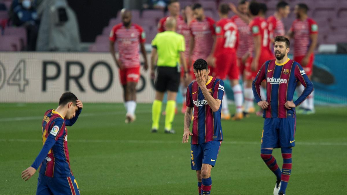 Pedri, Busquets y Piqué, desolados mientras los jugadores del Granada festejan el segundo gol.