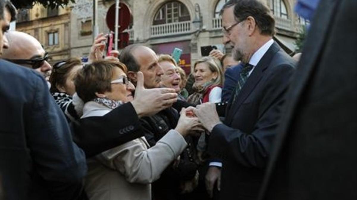 Mariano Rajoy saluda a simpatizantes en una calle de Sevilla