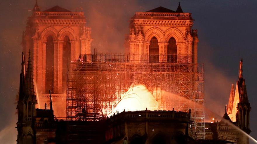 Las llamas asolaban Notre Dame entrada la noche.