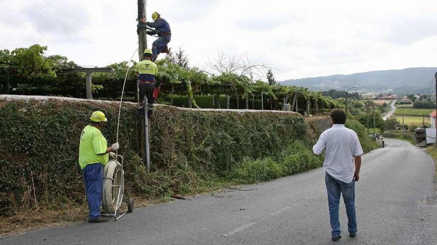 Operarios desplegando el cableado de la fibra óptica en O Sol el pasado jueves. // Bernabé