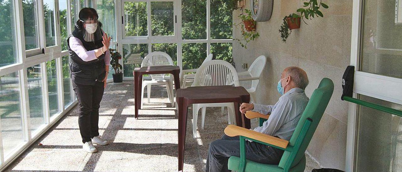 Silvia Quintas habla con su padre manteniendo la distancia en la primera visita familiar en la residencia San Martiño de Luíntra.