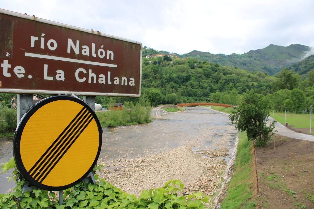 Vista general de La Chalana, con la zona en obras y la nueva pasarela sobre el Nalón al fondo.