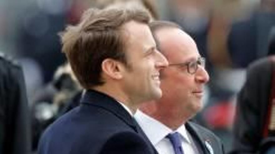 Hollande i Macron, abraçats en una cerimònia.