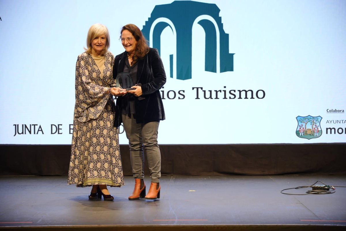 Victoria Bazaga entrega el galardón del Premio Turismo Extremadura a Adela Rueda, directora general de Bibliotecas de la Junta de Extremadura.