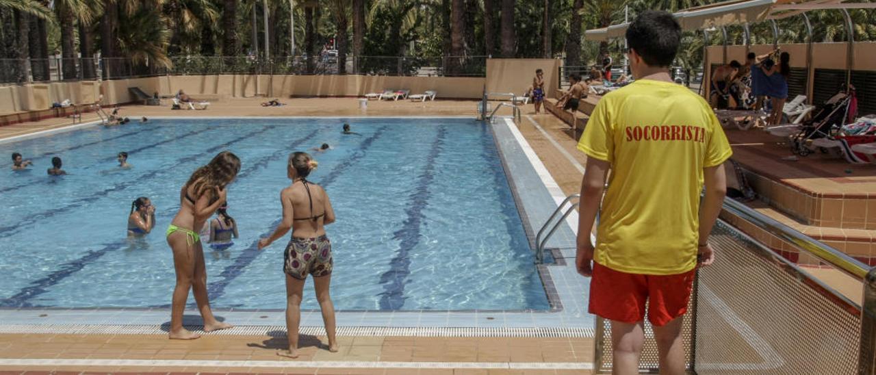 Un socorrista vigila el baño de usuarios de una piscina durante este verano.