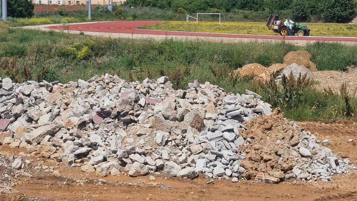 Escombros de la Rúa acumulados junto a las pistas de atletismo.