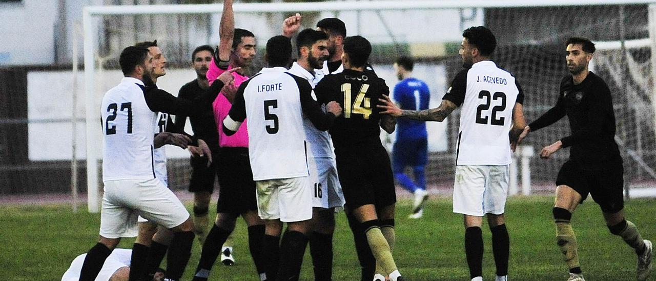 El colegiado muestra la cartulina roja al jugador del Intercity Coco tras entender que agredió a un contrario.