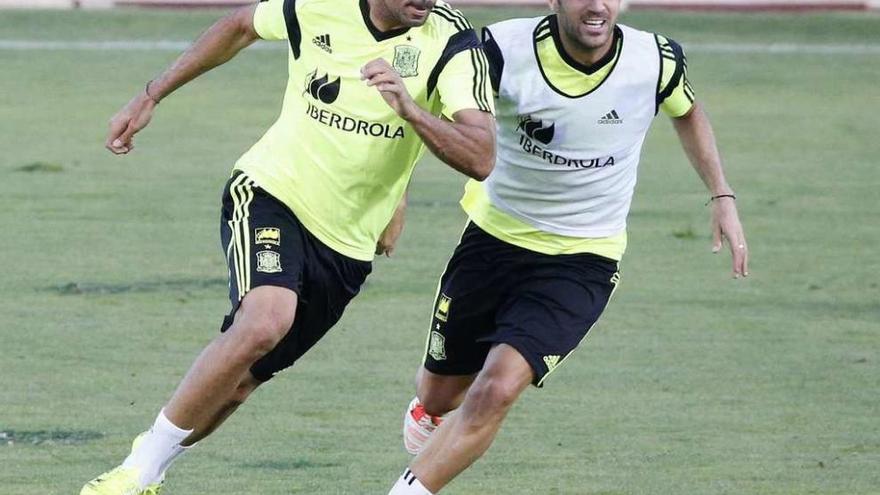 Cesc Fábregas persigue a su compañero del Chelsea Diego Costa, ayer, en Las Rozas. // Alberto Martín