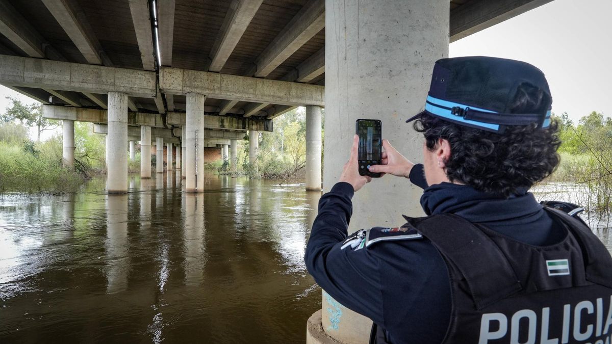 Una policía local registra el caudal bajo el puente del río Gévora, ayer.