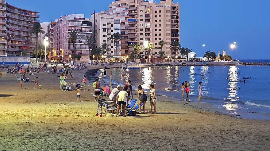 Playa del Cura de Torrevieja, repleta de bañistas, incluso con mesas y sillas, a las 22 horas, cuando el horario de cierre es a las 20.30 horas.