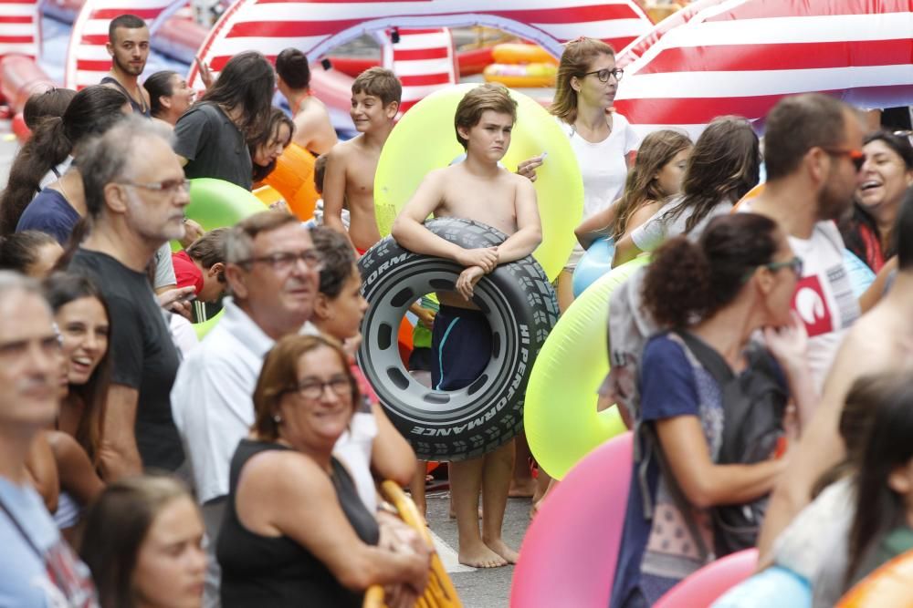 Cientos de personas disfrutan del tobogán acuático en la calle Colón