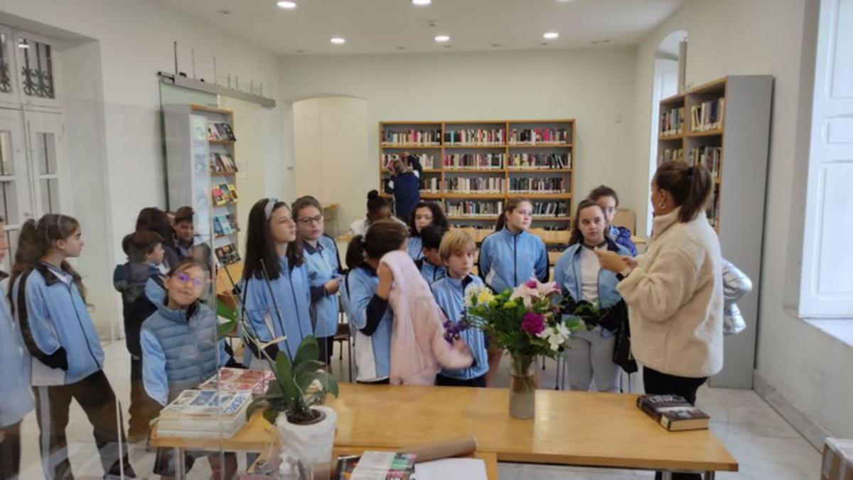 La directora de la biblioteca municipal explica a un grupo de escolares los servicios que ofrece la biblioteca. | E. P.