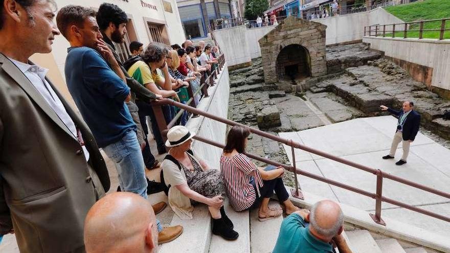 Sergio Ríos guía a los participantes en el congreso en la visita a la fuente de Foncalada, ayer.