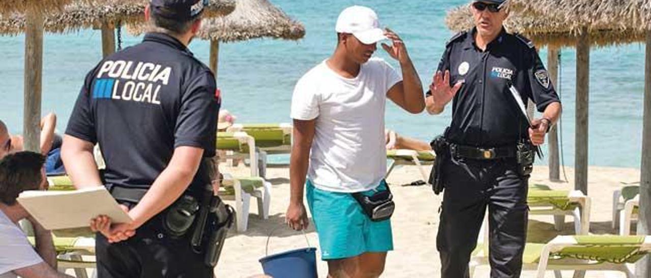 Los agentes sorprenden a un vendedor irregular de bebidas y refrescos en la arena.