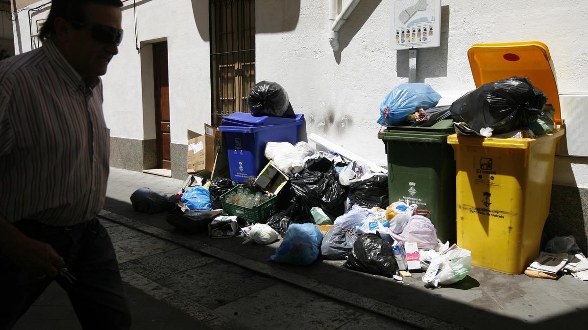 Imatge d'arxiu d'un usuari passant per davant d'un punt de recollida a Sant Feliu de Guíxols.