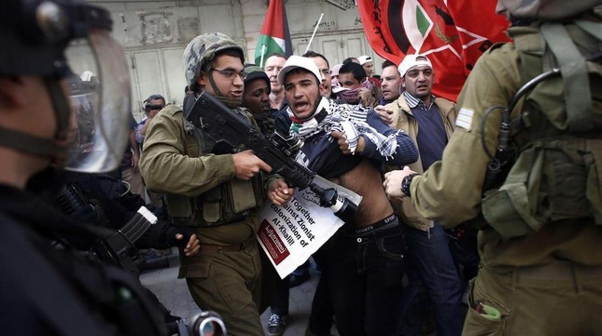 Palestins i soldats israelians forcegen al centre d’Hebron, aquest divendres.