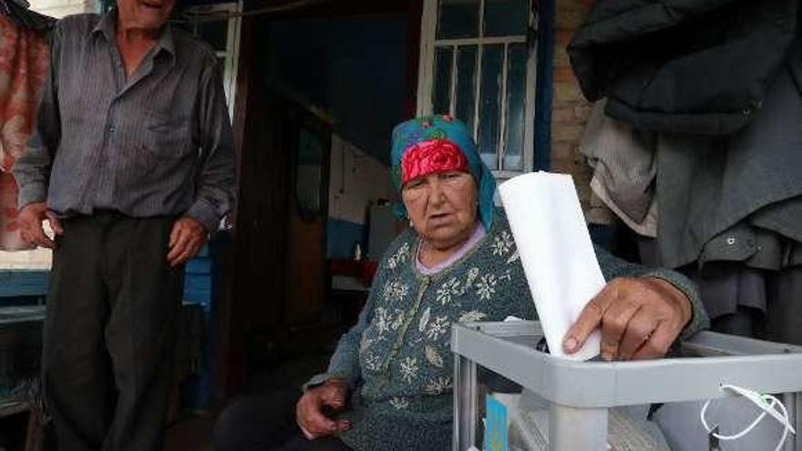 Una anciana vota en una urna móvil en Ucrania. // Efe