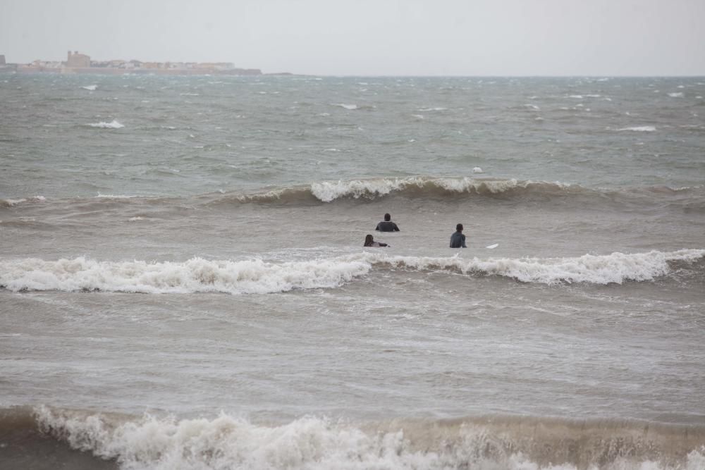 Mientras los ilicitanos se refugian en sus casas, otros aprovechan el temporal para practicar surf
