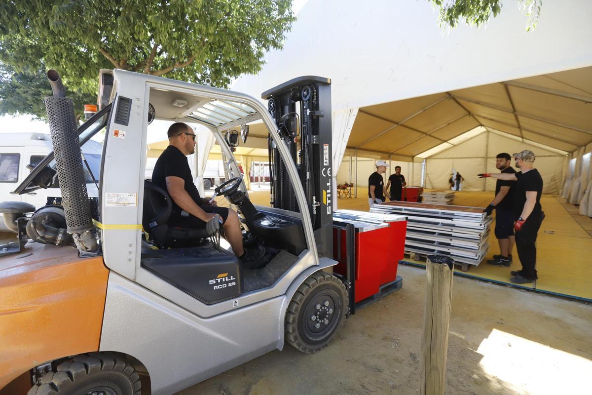 Trabajadores se encargan del montaje de una caseta de la Feria de Córdoba, este martes.