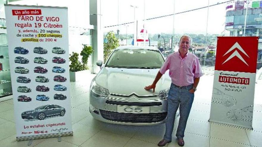 El vigués Enrique Bernárdez Rodríguez posa sonriente ante el deslumbrante Citroën C5 Hdi 110 FAP Collection, regalo de FARO a su fidelidad como lector, en Comercial Automoto. / rafa estévez