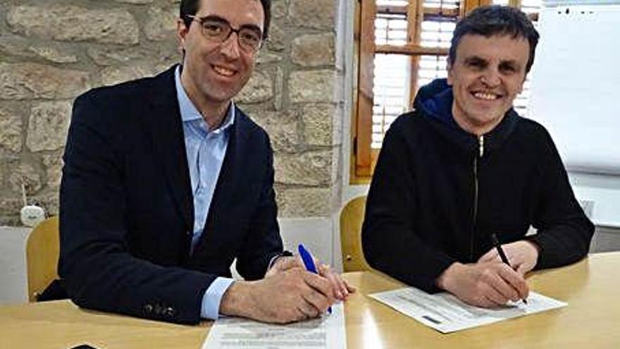 Carles Cuyàs i Eloi Oller signant el conveni, ahir a la seu del Consell