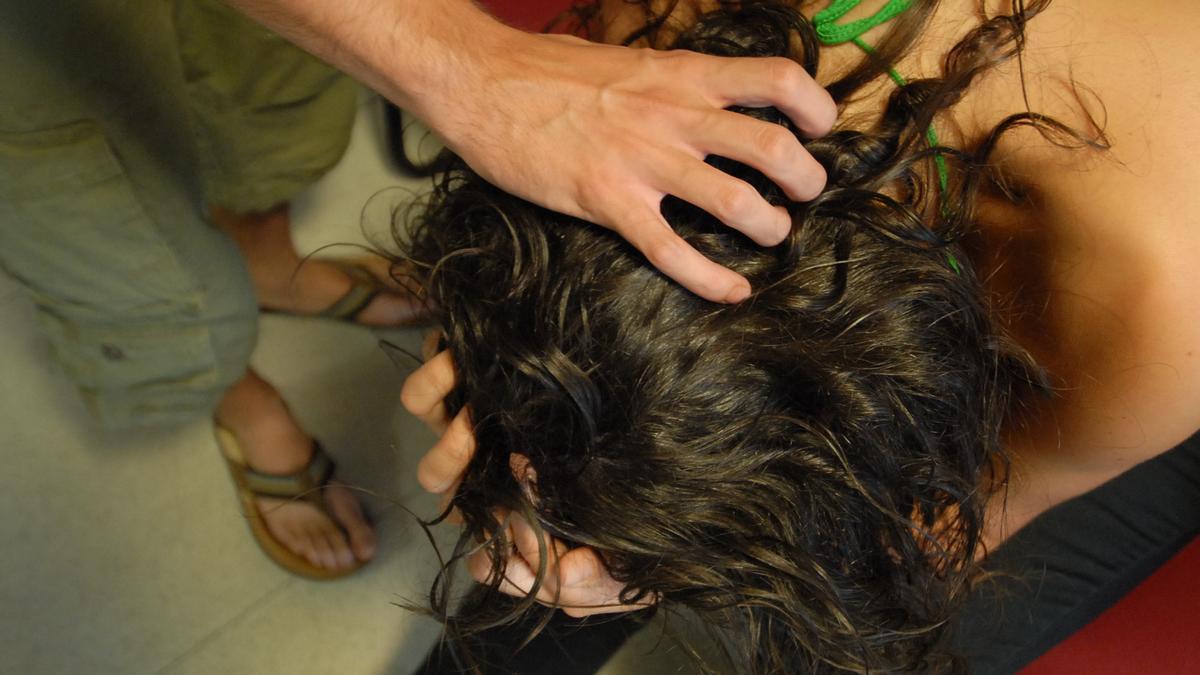 Una mujer se cubre la cara ante la agresión de un hombre.